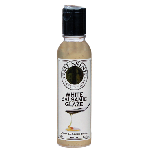 A bottle of Mussini White Balsamic Glaze with a label showing the product name and a small icon, against a white background.