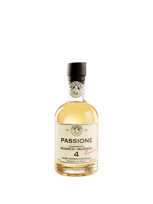 A bottle of Mussini White Balsamic Vinegar with a label that reads 'Passione Bianco Mussini 4'. The bottle cap is black, and the vinegar appears to be a light yellow color.
