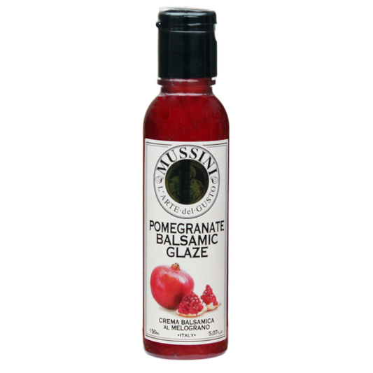 A bottle of Mussini pomegranate balsamic glaze with a label showing an image of a pomegranate and text describing the product as a cream of balsamic al melamato.