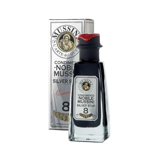 A bottle of Mussini Silver Star 8 Year Balsamic Vinegar with a red cap, next to its packaging box which bears the brand and product name.