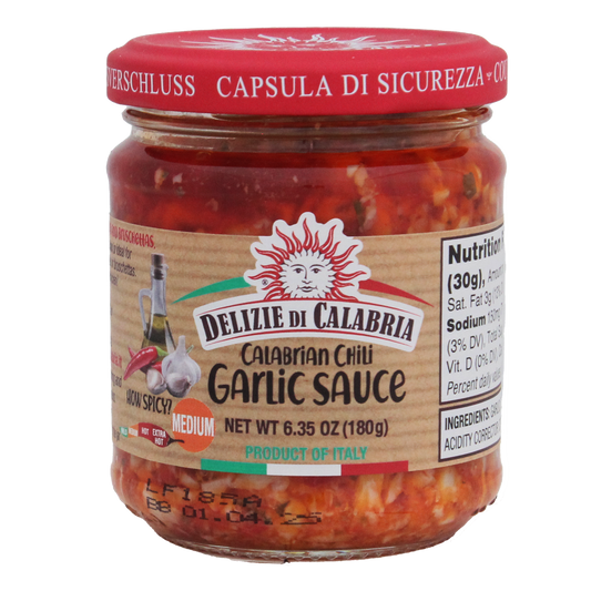 A jar of Calabrian Chili Garlic Sauce with a red label and the brand 'Delizie Di Calabria' visible on the label.