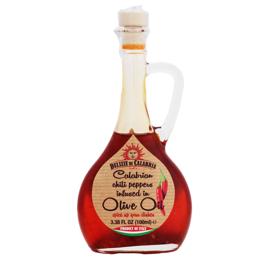 A bottle of Calabrian chili pepper infused olive oil with a white ceramic pourer. The label indicates the product is 3.38 fl oz